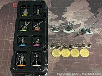Full view of Monopoly Star Wars metal pieces including character tokens in trays, spaceship miniatures, infantry miniatures, and collectible gold-colored coins.