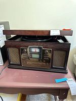 Front view of Crowley radio with wooden casing, showing control panel with analog dial, speakers, and display.