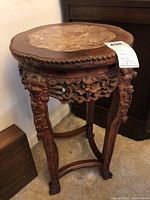 Full view of carved wood side table with circular stone top