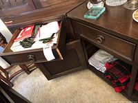 Open cabinet drawers and shelves showing folded napkins, placemats, and cloth fabrics in various colors including red, white, green, yellow, and magenta.