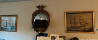Panoramic view showing two framed nautical prints flanking a gold-tone eagle mirror