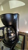 Photo of the Mr. Coffee drip coffee maker showing the upper part, including the water reservoir and glass carafe.