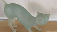 Close-up of the opaque glass cat figurine highlighting the frosted glass texture and playful pose.