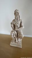 Full view of the Moses statue showing the front side seated on a base, highlighting facial features, beard, and drapery.