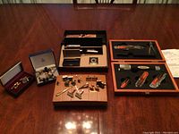 Overall lot view showing pen set, cufflinks, tie bars and multi-tool case