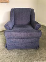 Front view of blue upholstered armchair showing cushioned seat, padded roll arms, and textured fabric.