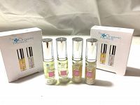 Four bottles of serum and face gel from The Organic Pharmacy displayed in front of two product boxes labeled Protect & Repair Serum Duo, showing the individual bottles and packaging.