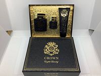 Gift set box with two eau de parfum bottles and 3-in-1 shampoo conditioner body wash tube arranged inside with gold background showing the branding