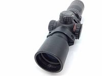 Front angled side view of black matte cylindrical rifle scope showing objective lens and front adjustment knob