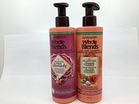Two bottles of Garnier Whole Blends shampoo, Colour Protecting and Curl Care, both 355ml with pump tops