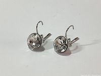 Front view of genuine Swarovski earrings showing large round solitaire diamond cut crystals set in silver rhodium plated metal.