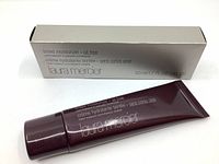 Photo of Laura Mercier Tinted Moisturizer tube in shade Sand and its silver box packaging with product details visible.
