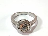 Close-up image of Swarovski ring from top showing bezel set central crystal and halo of pave crystals on silver rhodium band.