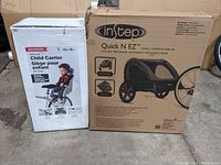 Front view of boxed InStep Quick N EZ trailer and Schwinn child carrier seat