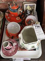 Tray with Chinese dragon themed teapot and cup, red transferware cup and saucer, white ironstone creamer, and assorted coasters