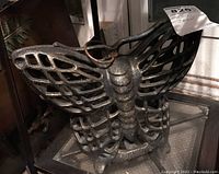 Front view of cast iron butterfly candle holder showing wing pattern and hanging ring