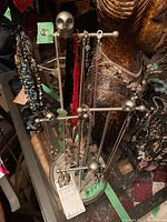 Front view of the 18-inch metal jewelry stand holding assorted necklaces, bracelets, and earrings.