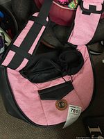 Pink and black striped dog clothing with black booties and a carrying bag showing Pet Lovolager branding.