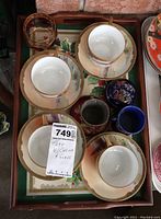 Teacups and saucers arranged inside the holly and ivy service tray, showing the set and additional glasses.