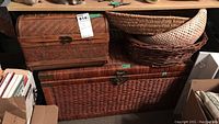 Large and smaller wicker storage boxes stacked with two wicker baskets on top