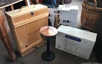 Wooden wine crate, Umbrella Torch oil lamps with packaging, and a wicker basket in the background
