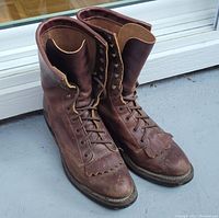 Front view of the brown leather Boulet boots showing the toe and lacing area with fringed detail.