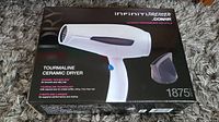 Photo of the Conair Infiniti Premier blow dryer box showing the product image, tourmaline ceramic dryer details, wattage, and heat/speed settings.