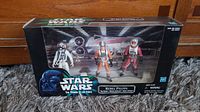 Front view of the original sealed box containing three Star Wars Rebel Pilots action figures with visible branding and background artwork.