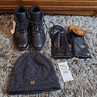 Full lot showing Soia & Kyo mittens, Khombu boots, and Roots toque laid out on carpet.