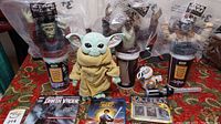 Overview of Star Wars collectibles including figures, cup toppers, Blu-ray, CD, and other items arranged on table