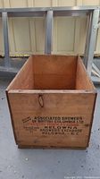 Front view of the wooden apple crate showing the printed text 'Associated Growers of British Columbia Ltd. Head Office Vernon, B.C. Canada, Packed and shipped by Growers Exchange Kelowna, B.C.' and a wood knot on the top left corner.