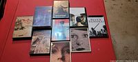View of all nine Criterion Collection DVDs laid out on a red surface.