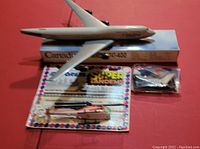 The Air Canada Boeing 747-400 die-cast model plane displayed on top of its original box beside the sealed model helicopter in package with backing card.