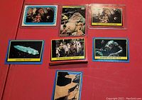 Close up photo of six Return of the Jedi collectible cards including Jabba the Hutt and Princess Leia, Rebel Cruiser, Stormtroopers, Morloq from the Pit