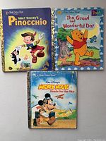 Front covers of three Little Golden Books featuring Walt Disney's Pinocchio, Winnie the Pooh, and Mickey Mouse.