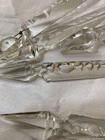 Close-up photo of several clear glass hanging prisms showing minor bruising and small chips to some edges.