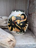 Full view of Celtic Pottery vase showing black and brown abstract design on cream-colored body with dripping green rim.