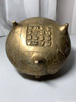 Bottom view showing square seal with Chinese characters and engraved design on gilt bronze surface.