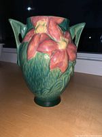 Front and detail view of Roseville Clematis green pottery vase with pink flowers and handles.