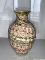 Front view of signed swirl pottery vase showing marbled swirl pattern and flared lip.