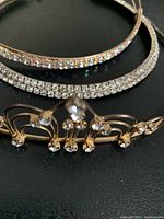 Close view of rhinestone headbands and gold-tone tiara headband showing faux pearl details