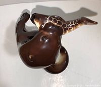 Top view photo showing brown glossy finish and fish detail in otter's mouth