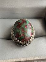 Front view of the Whiting and Davis ring featuring the multicolored stone in a decorative silver-tone bezel setting.