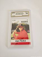 Front view of Albert Pujols rookie baseball card in protective graded case showing Gem Mint 10 grade and card image of Pujols in red uniform with bat.