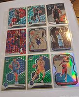 Full page collection of 9 basketball cards in sleeve showing various players and holographic cracked ice designs