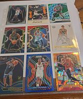Nine basketball cards arranged in a plastic sleeve at an angle, including rookies and rare inserts with holographic and cracked ice designs.