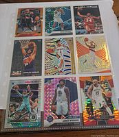 Full nine-card sheet in plastic sleeve showing various basketball cards with holographic and cracked ice finishes.