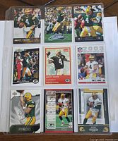 Photo showing nine Brett Favre football cards inserted in a plastic collector's sleeve. Top row features three cards, middle row three cards, and bottom row three cards. All cards depict Brett Favre in his Green Bay Packers uniform with two cards showing him passing and one in a running pose.