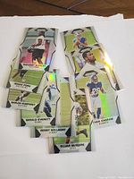 Group of eight football rookie cards with holographic foil detailing.