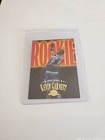 Front view of Kevin Garnett rookie card with large 'ROOKIE' text and player action image.